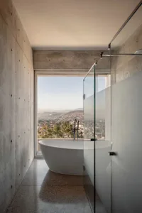 Modern residential bathroom with spa features and concrete walls.