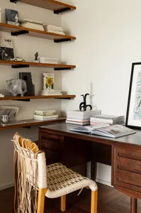 A home office with a wooden desk, shelves, and books.