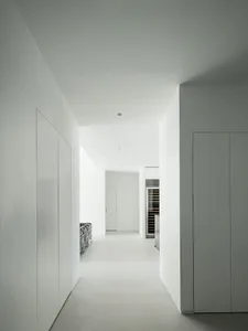 A minimalist apartment kitchen with concrete walls and floor.