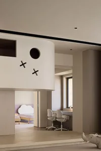 A minimalist residential interior featuring a wooden floor and furniture.