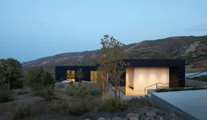 A modern building made of concrete with a flat roof and large windows.