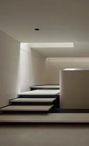 Modern staircase with concrete steps and white walls.
