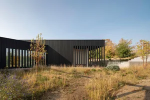 A modern contemporary exterior building facade with a metal-cladding and glass exterior design.