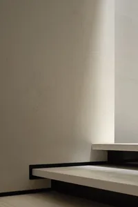 A minimalist, modern interior space with concrete flooring and walls.