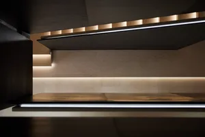 An interior space featuring concrete walls, illuminated by modern lighting fixtures.
