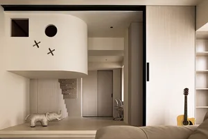 A modern living space featuring a concrete fireplace and staircase with an elephant sculpture and guitar.