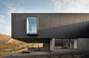 A modern building with a metallic exterior in a natural setting.