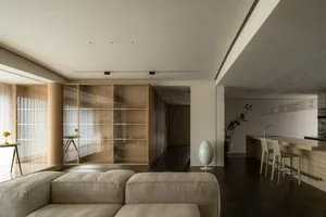 A modern minimalist living room featuring wood and glass elements.