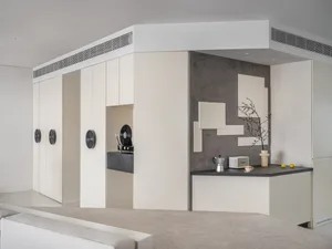 A minimalist kitchen with concrete walls and a black countertop.