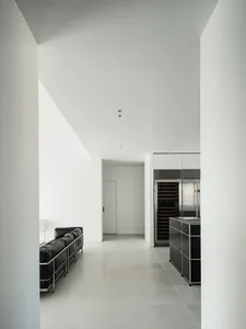 A modern minimalist interior design featuring concrete walls and floor.