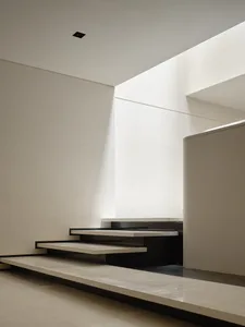 Modern interior space with minimalist design, featuring a minimalist staircase with white marble steps and black marble rails