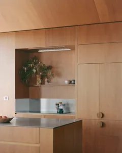 A modern, minimalist kitchen with wooden cabinets, stainless steel appliances, and a sleek design.