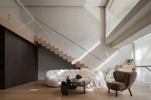 A modern minimalist living room with white furniture and wooden accents.