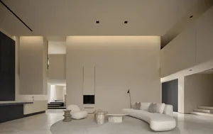 Modern minimalist living room with a concrete fireplace, curved white sofa, and geometric tables on a round rug.