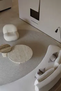 Modern minimalist living room with white marble furniture and wall architecture.