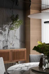 Modern dining room with wooden walls, metallic accents, and marble table