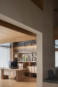 A modern home office with wooden furniture and shelving.