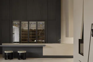 A modern minimalist mini kitchen with marble countertops and dark wooden cabinets.