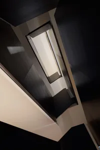 Modern interior design featuring a black metal stairwell with a window.