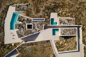 A modern concrete house with an outdoor space featuring a pool and garden.