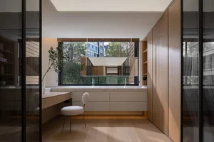 Modern minimalist bathroom vanity with a window, featuring clean lines and a sleek design.