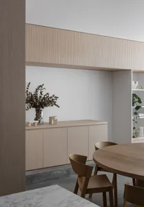A minimalist interior featuring wood cabinets and furniture. Modern and clean space with a focus on simplicity and functional