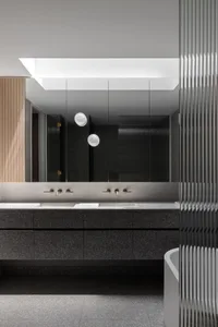 Modern bathroom featuring dark stone countertops and a minimalist design.