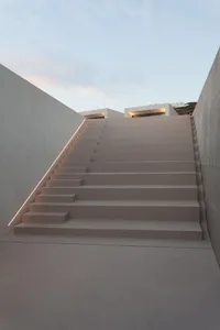 Concrete stairs with decorative lighting installed under the handrail.