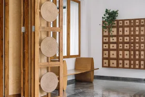 A modern living room featuring wooden furniture and decor, with geometric patterns and a minimalist design.