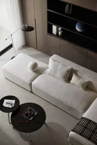 Modern living room featuring fabric couches and marble side tables.