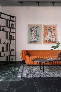 Modern living room featuring a sofa with a velvet texture and marble flooring.