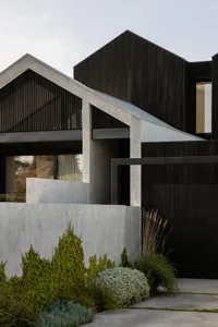 Modern residential exterior featuring concrete and wood materials.