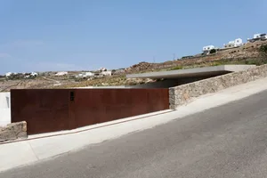 Modern residential entrance featuring a steel gate with a concrete ledge.