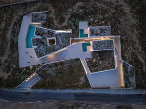 Aerial view of a modern residential house with concrete floors and a swimming pool.
