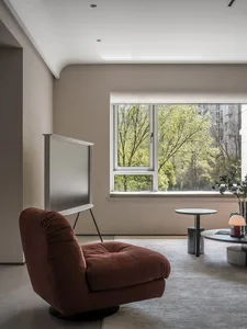 Modern living room featuring a purple upholstered chair and a white, flat-screen television.