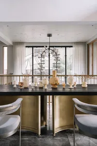 A modern dining room featuring marble tables and gold accents.