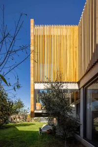 Modern house exterior featuring wooden slats and concrete foundation.