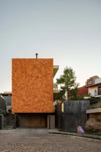 A modern residential building with a terracotta-tiled facade.