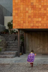 A modern house entrance with hexagonal terracotta tiles on the wall.