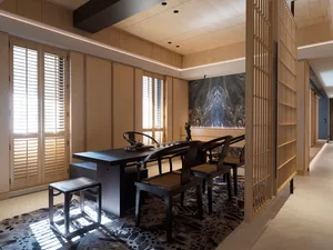 A modern interior space featuring wooden furniture, marble accents, and glass elements.