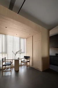 A minimalist residential dining area with wood walls and floor.