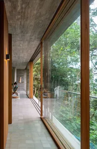 Modern residential interior with large glass window and concrete ceiling.
