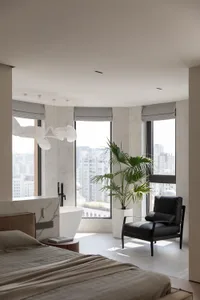 A minimalist bedroom featuring marble walls and a large window with a city view.