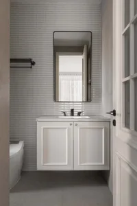 Modern bathroom with concrete and marble tiles featuring a floating vanity with a mirror above and a sink with black faucets.