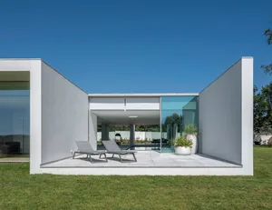 Modern house exterior with glass walls and lawn