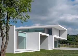 Modern house exterior with glass walls and concrete structure
