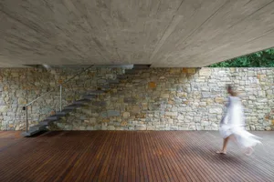 A modern interior space featuring a brick floor and walls, with a concrete ceiling and natural light.