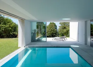 Modern interior design featuring a glass swimming pool.