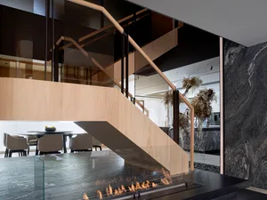 Modern residential interior with a wood and glass staircase.