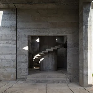 A modern architectural interior featuring exposed concrete walls and stairs.
